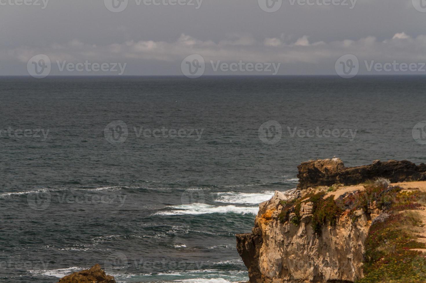 The waves fighting about deserted rocky coast of Atlantic ocean, Portugal photo