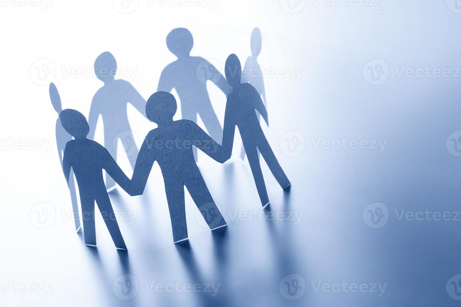 Paper people standing together hand in hand. Team, glabal business connection concept photo