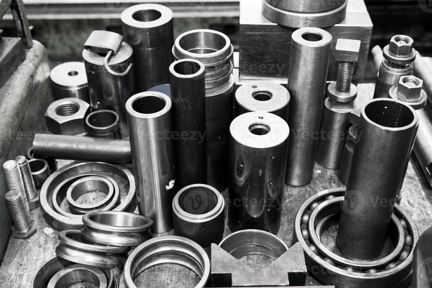Steel cylinders, pistons and tools in workshop. Industry theme. photo