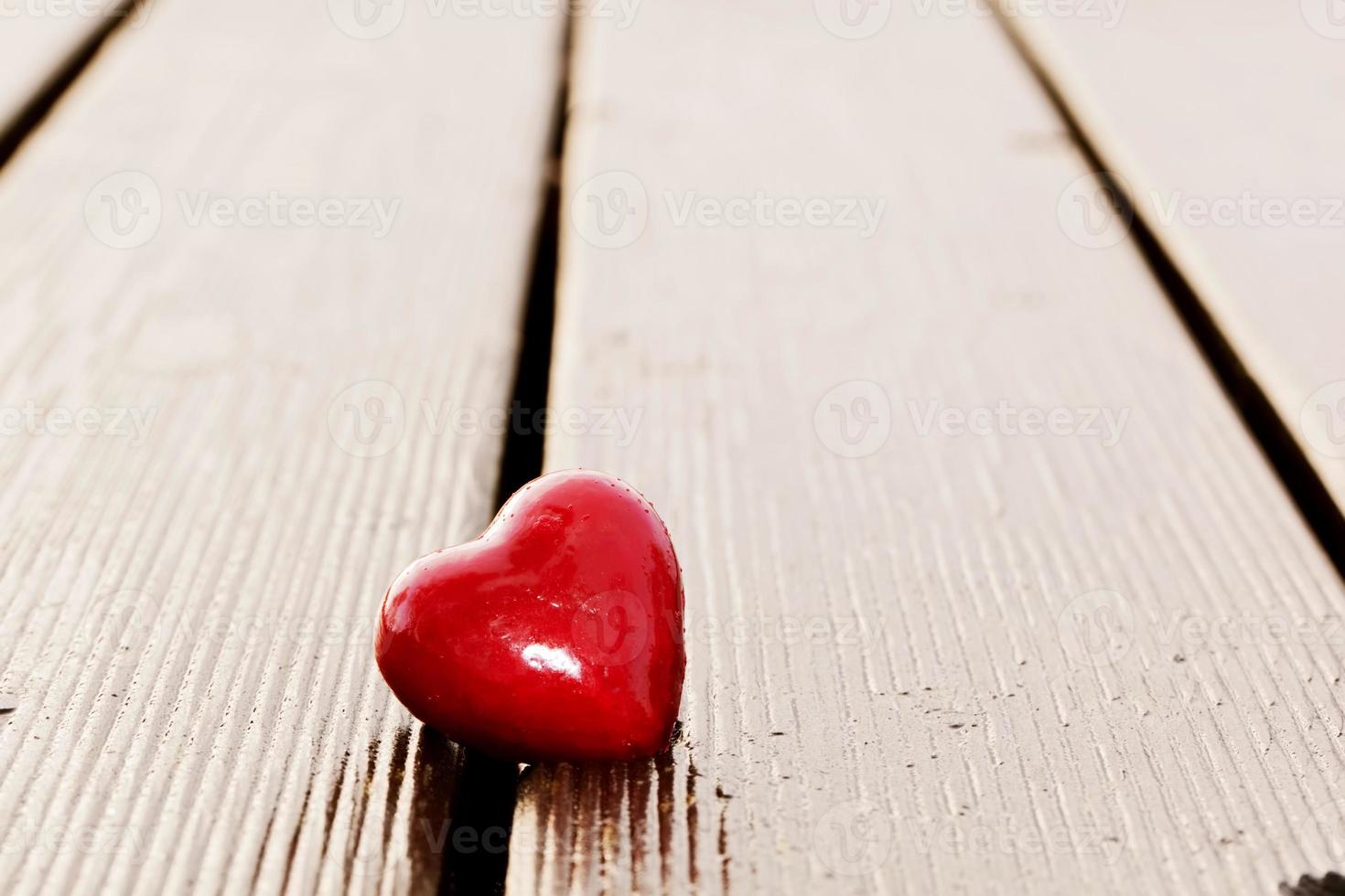 Red heart in crack of wooden plank. Symbol of love photo