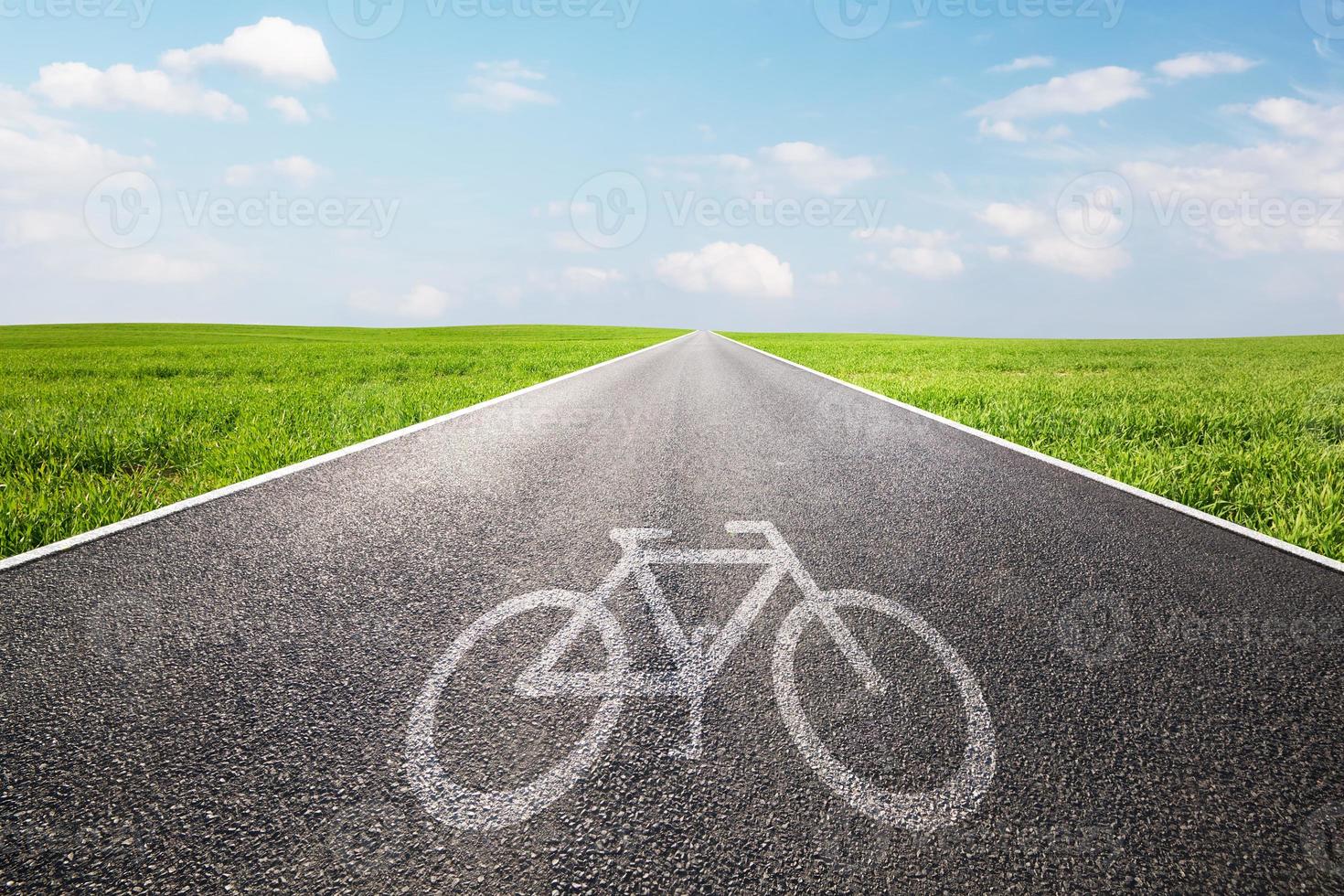 símbolo de bicicleta en una larga y recta carretera asfaltada, camino foto