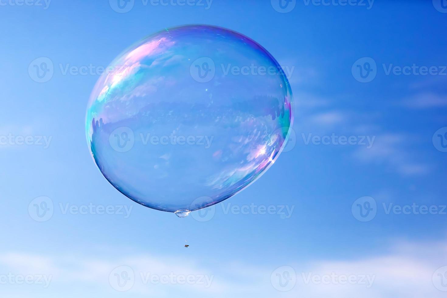 una burbuja de jabón limpia volando en el aire, cielo azul. foto