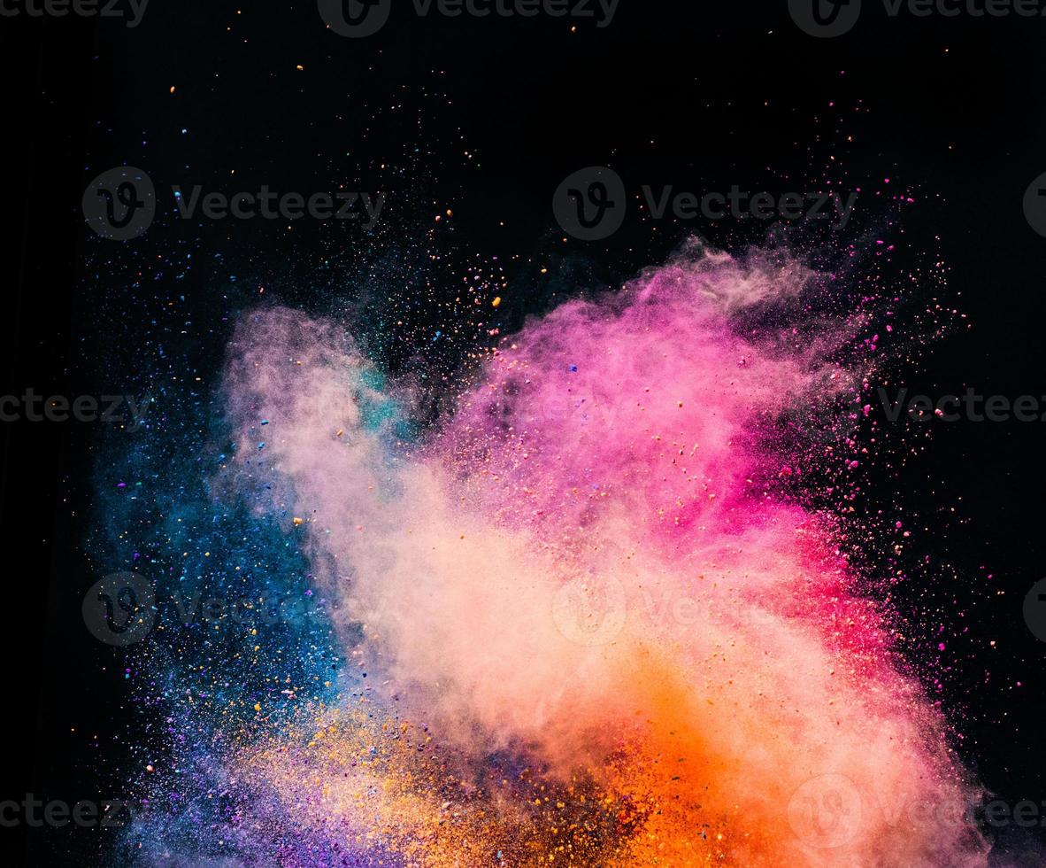 Colorful holi powder blowing up on black background. photo