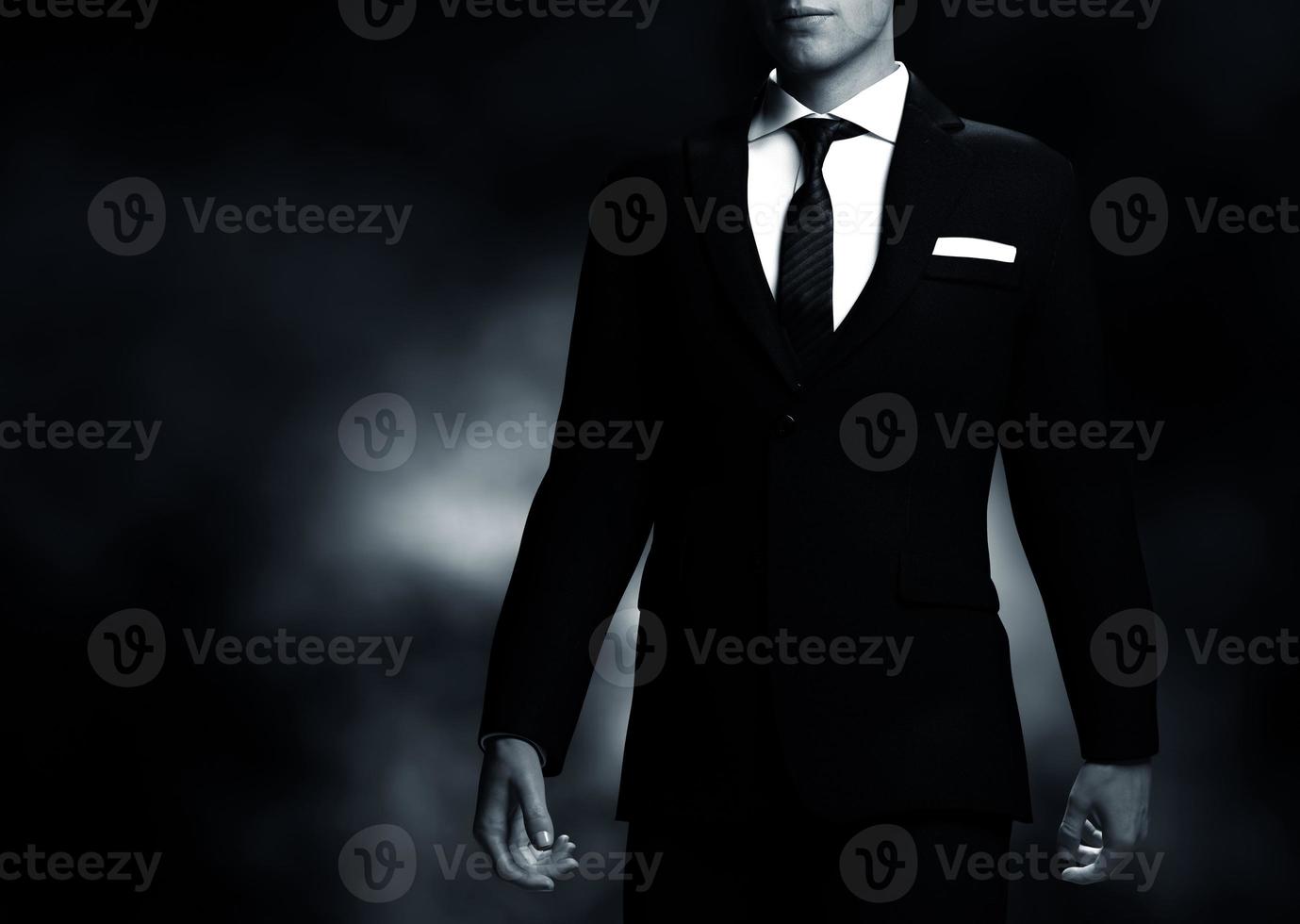 Businessman, gentleman in elegant suit on black background. Middle body view photo