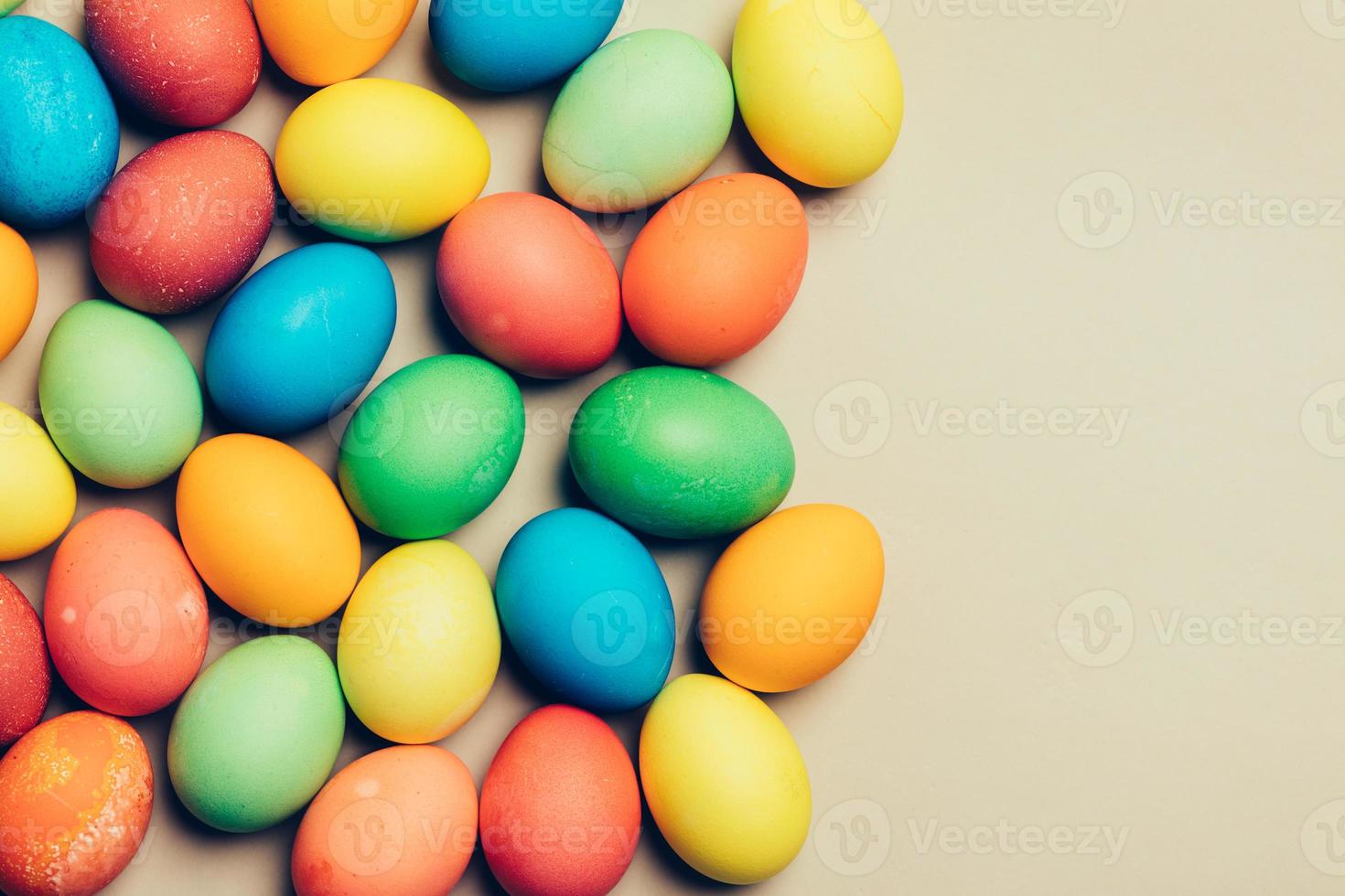 Couple of dyed eggs laying on a creamy background. photo