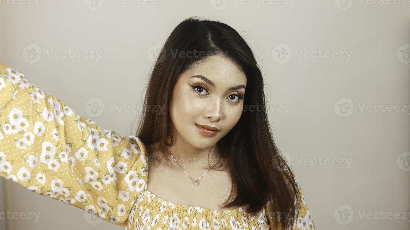 sonriente joven mujer asiática con maquillaje aislado con fondo blanco. concepto de belleza. foto