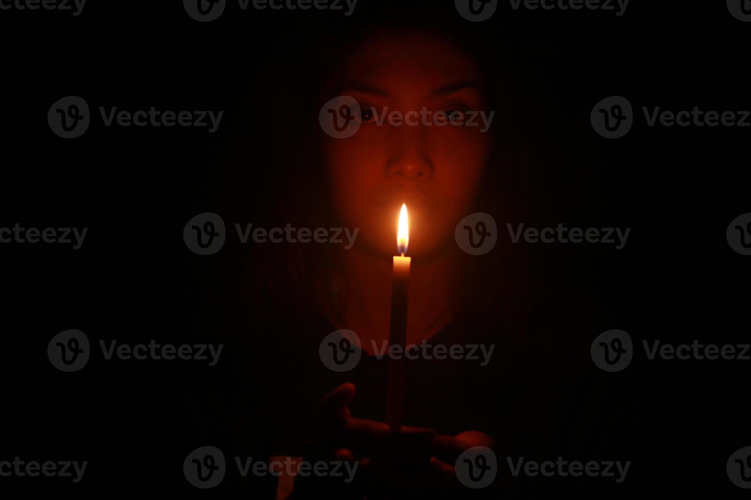 a spooky Asian woman with candle in the dark night photo