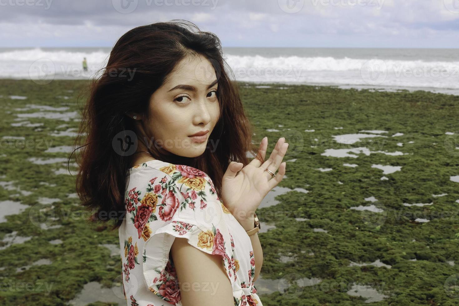 A young Asian girl on the beach is smiling at the camera at Gunungkidul, Indonesia photo