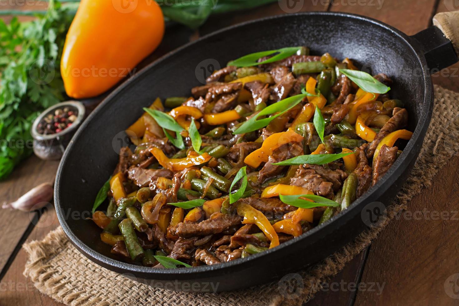 Stir frying beef with sweet peppers and green beans photo