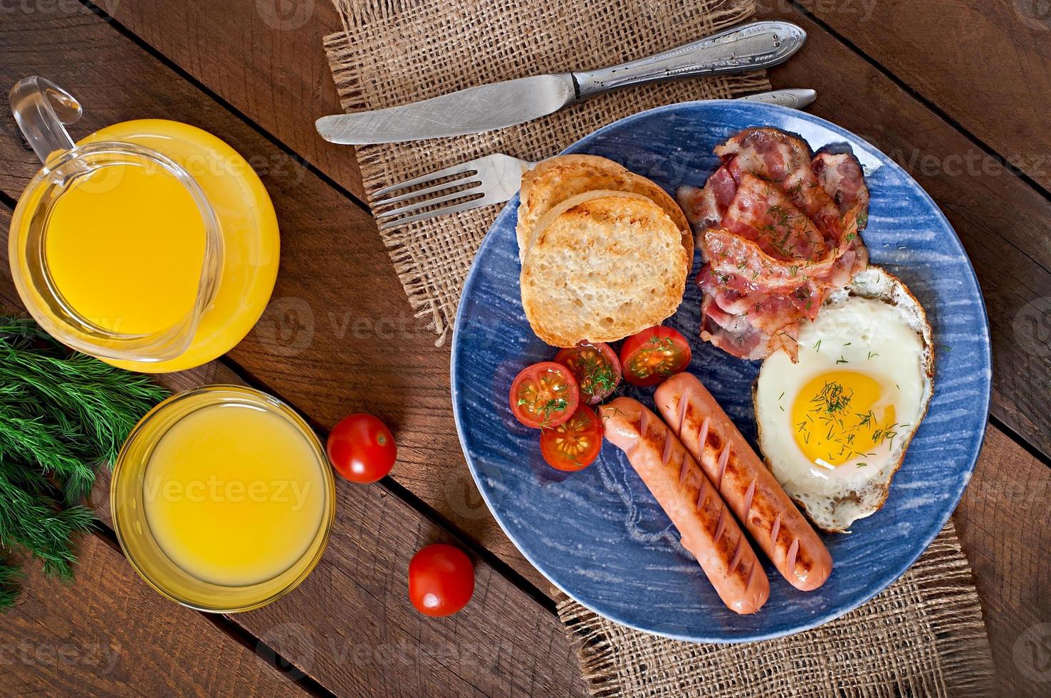 English breakfast - toast, egg, bacon and vegetables in a rustic style on wooden background photo
