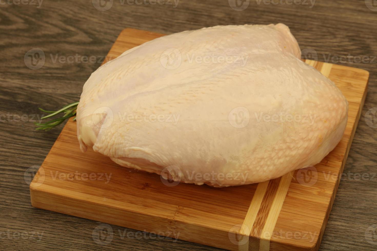 Raw whole chicken breast with skin photo