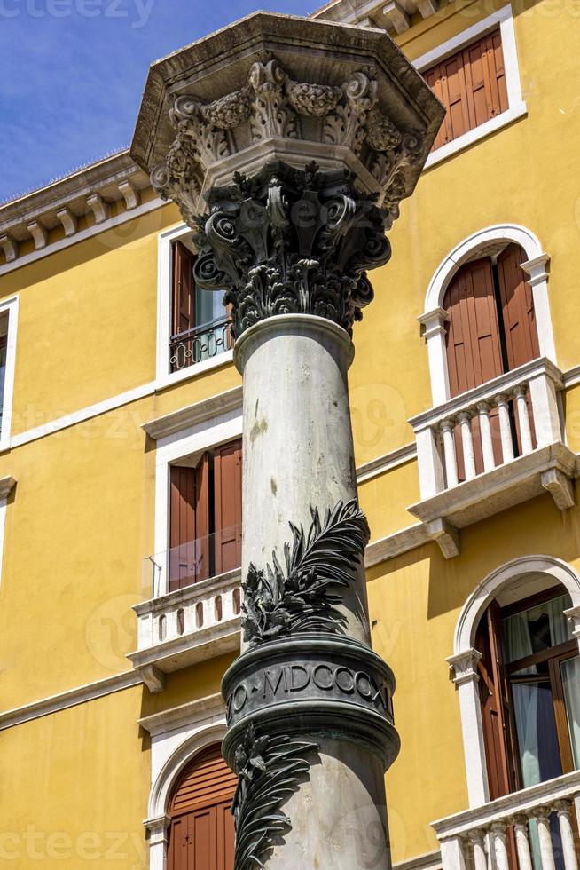 Traditional antique column on the street of Venice photo