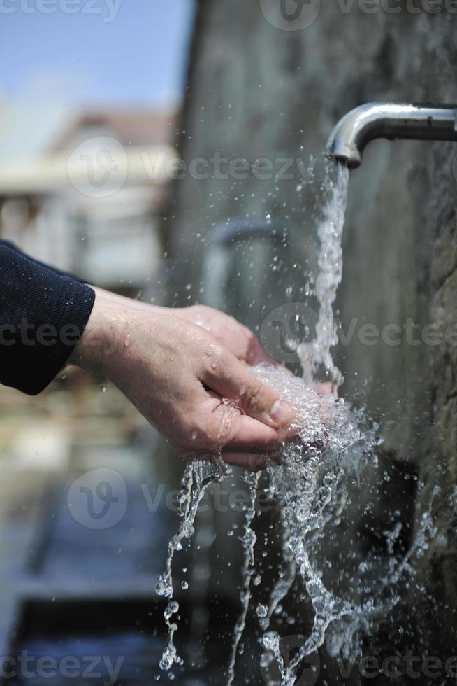 agua fresca de montaña cayendo sobre las manos foto