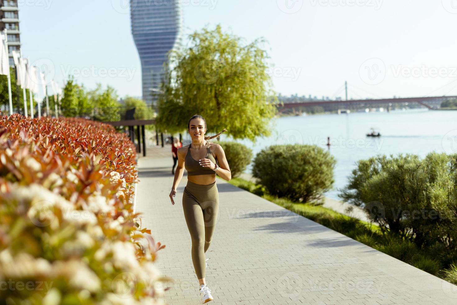 Young woman taking running exercise by the river promenade photo