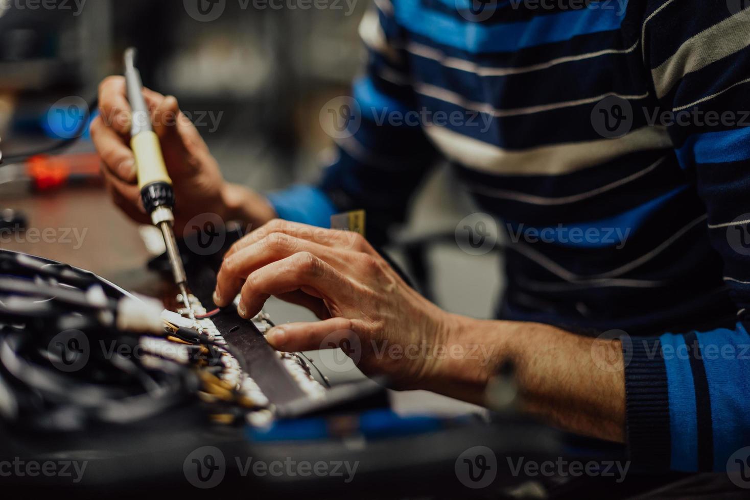 trabajador industrial hombre soldando cables de equipos de fabricación en una fábrica. enfoque selectivo foto