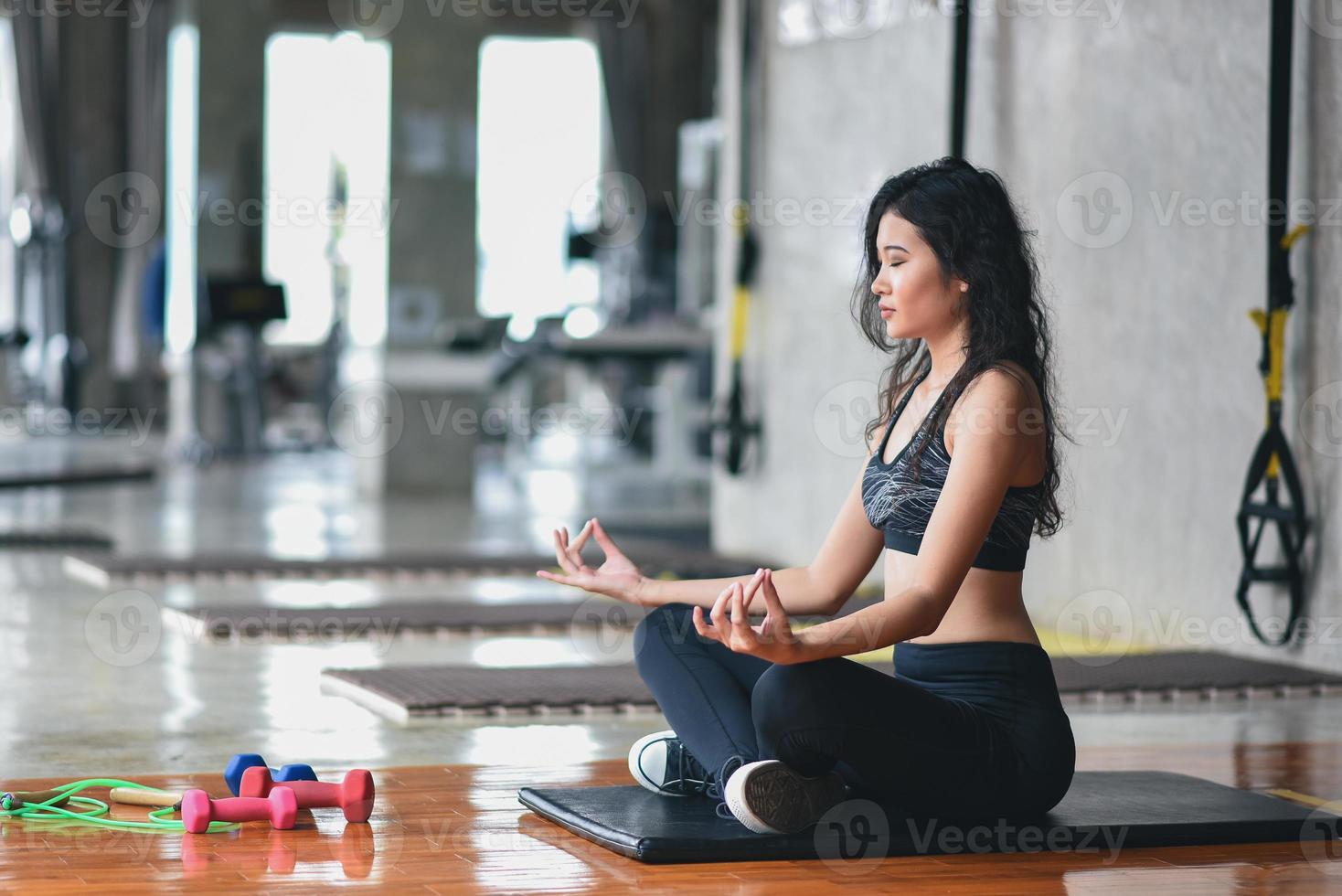 sport asian woman practicing yoga lesson, breathing, meditating, doing Ardha Padmasana exercise, working out in the gym photo