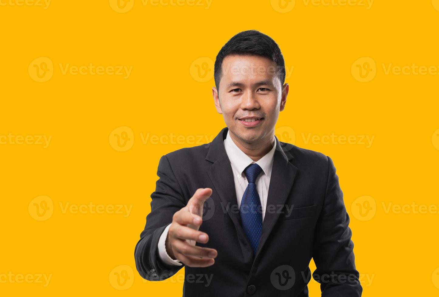 Asian business man wearing suit offering a handshake and smiling on isolated yellow background. Business concept asian man want to offering handshake. photo