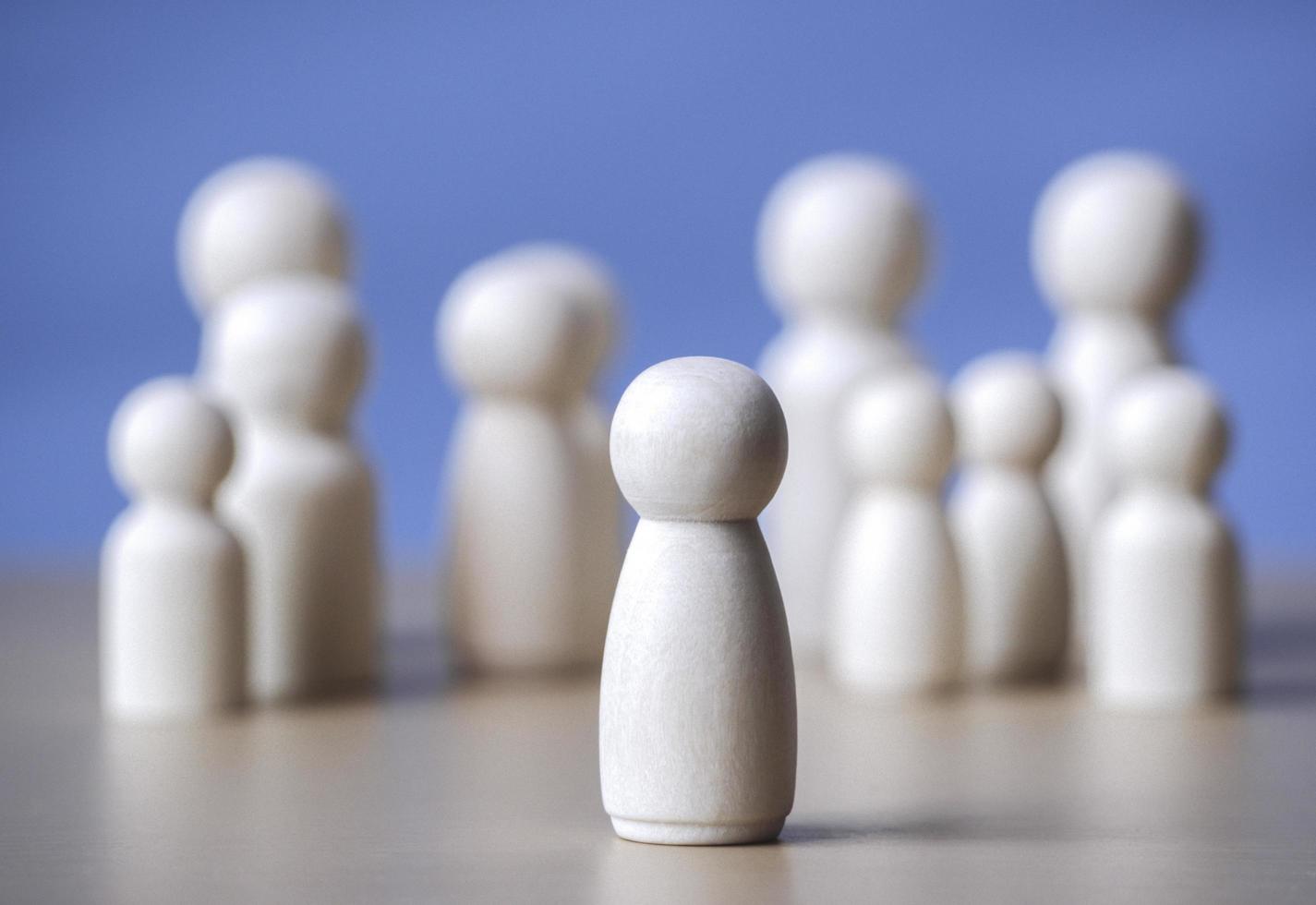 Wooden figure standing on the wooden block to talking leadingship for influence, empowerment and inspiration for crowd. Leader with influence, leader team and successful competition winner concept. photo