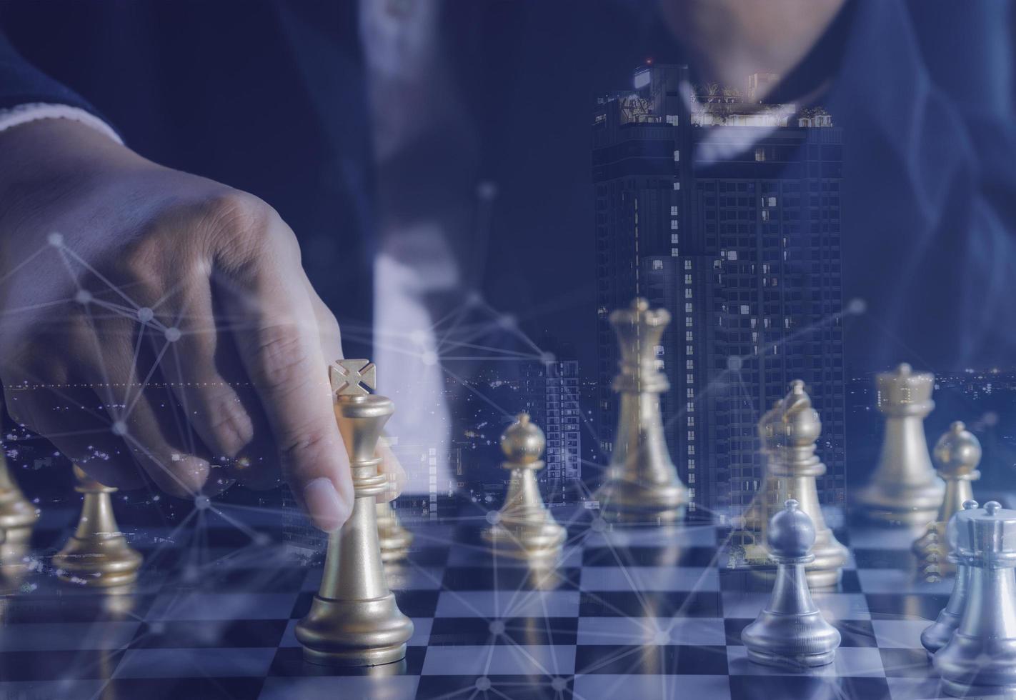 Hand of businessman holding gold king chess on stock market or forex trading graph chart with cityscape image economy trend for digital financial investment.Management or leadership strategy concept. photo