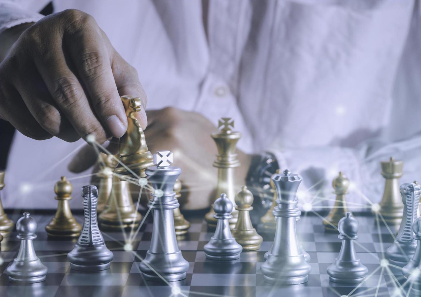 Hand of businessman holding gold king chess on stock market or forex trading graph chart with cityscape image economy trend for digital financial investment.Management or leadership strategy concept. photo