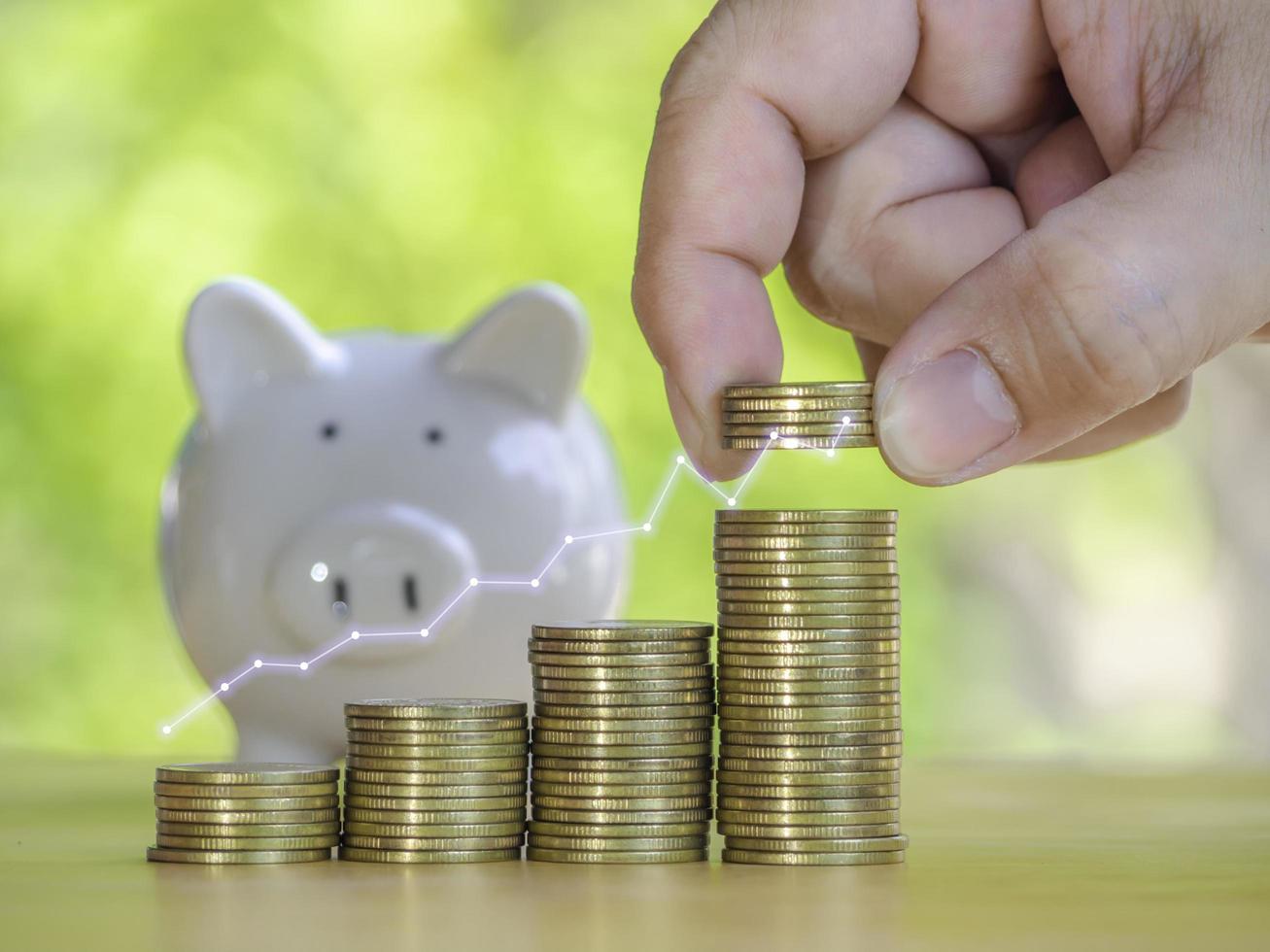 Hand are stacking coins with alarm clock to save the financial stability for the future. Concept for loan, property ladder, financial, mortgage, real estate investment, taxes and bonus. photo