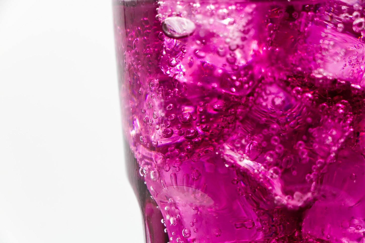 Grape sparkling water with Ice in glass over white background. photo