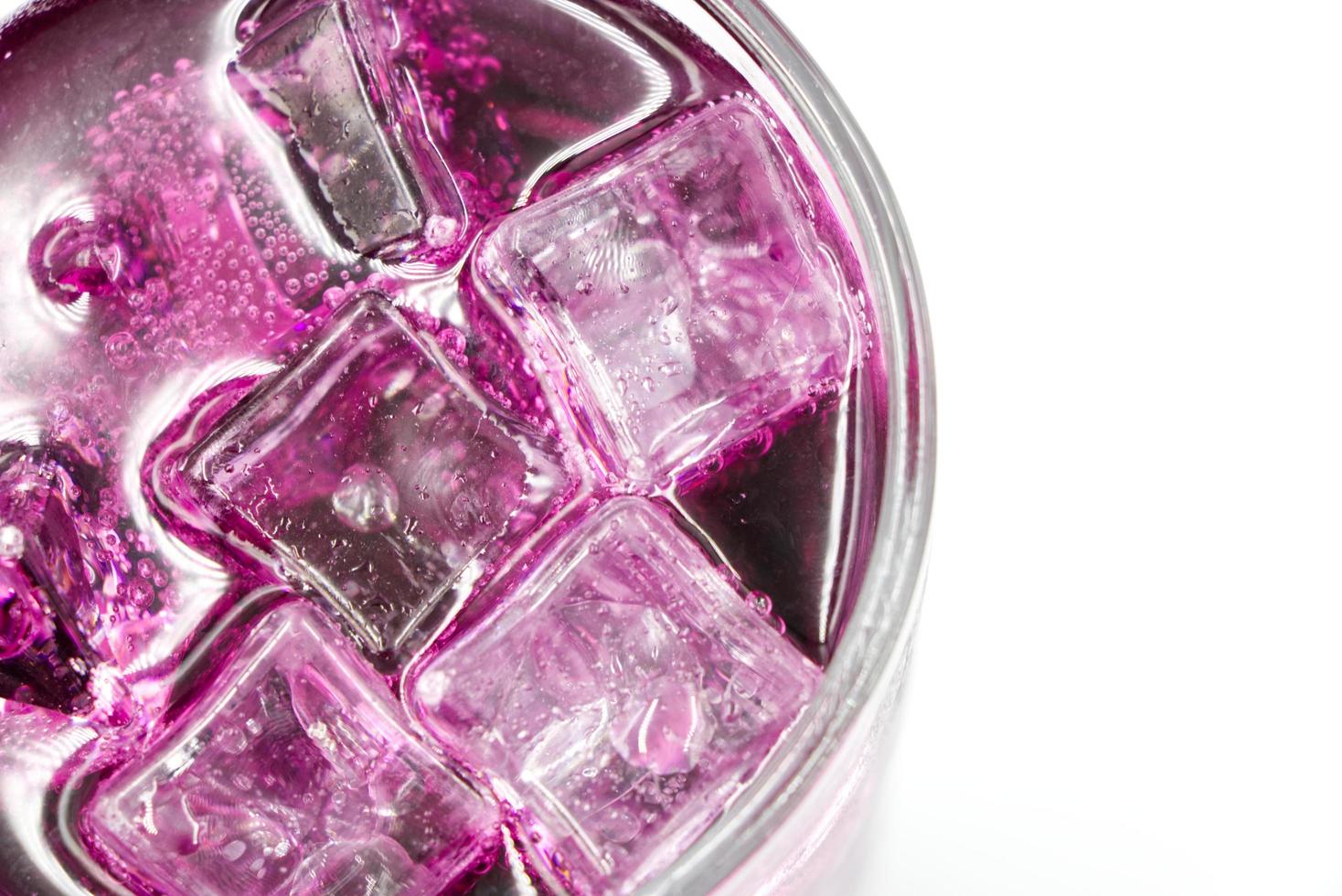 Grape sparkling water with Ice in glass over white background. photo