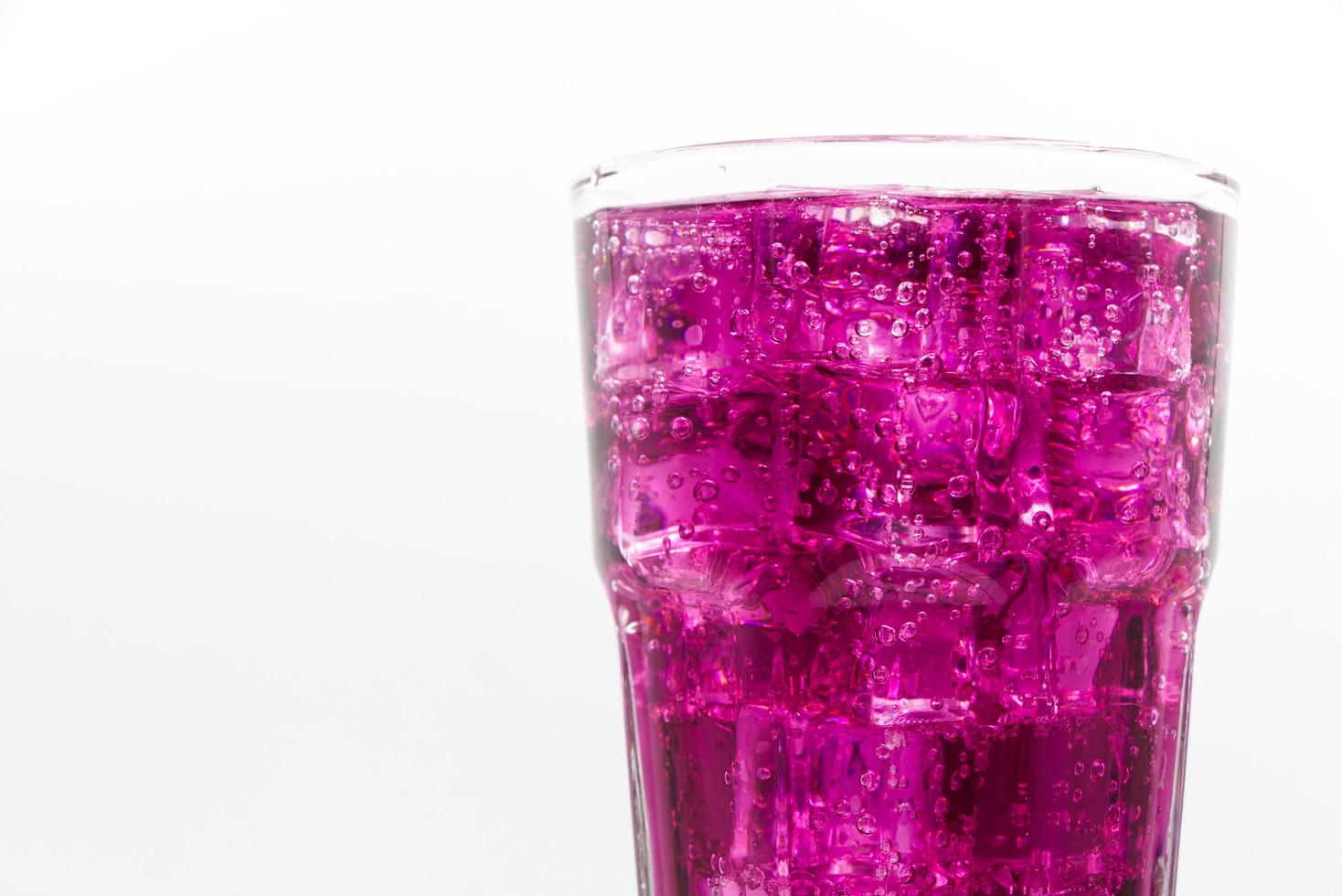 Grape sparkling water with Ice in glass over white background. photo
