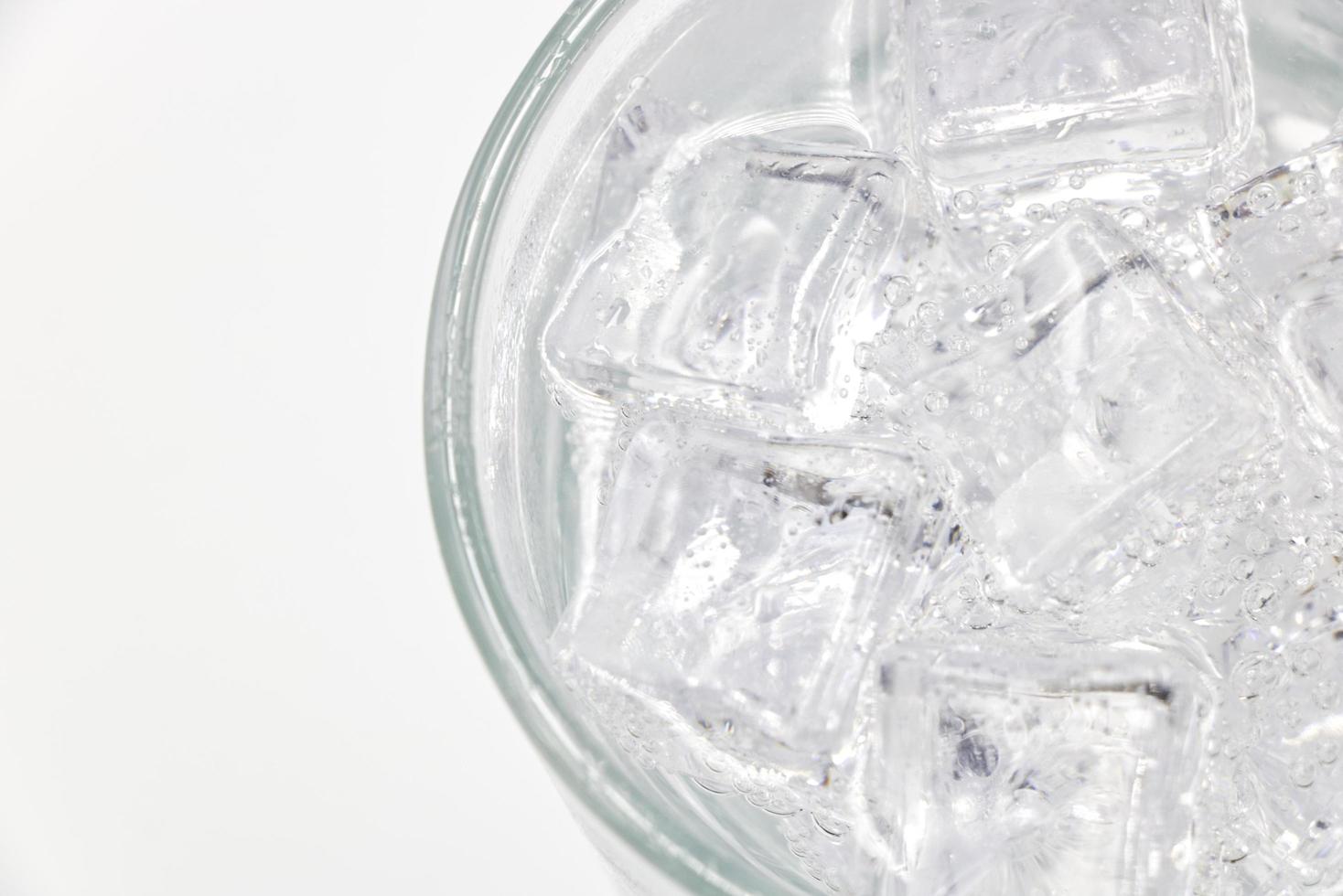 Soda sparkling water with Ice in glass over white background. photo