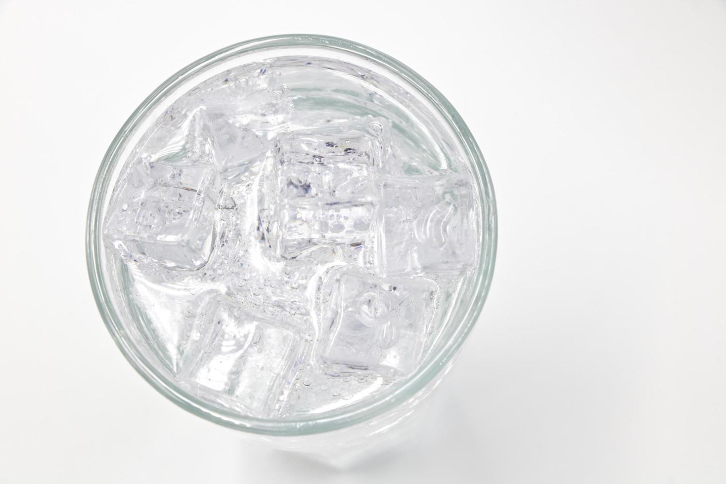 Soda sparkling water with Ice in glass over white background. photo