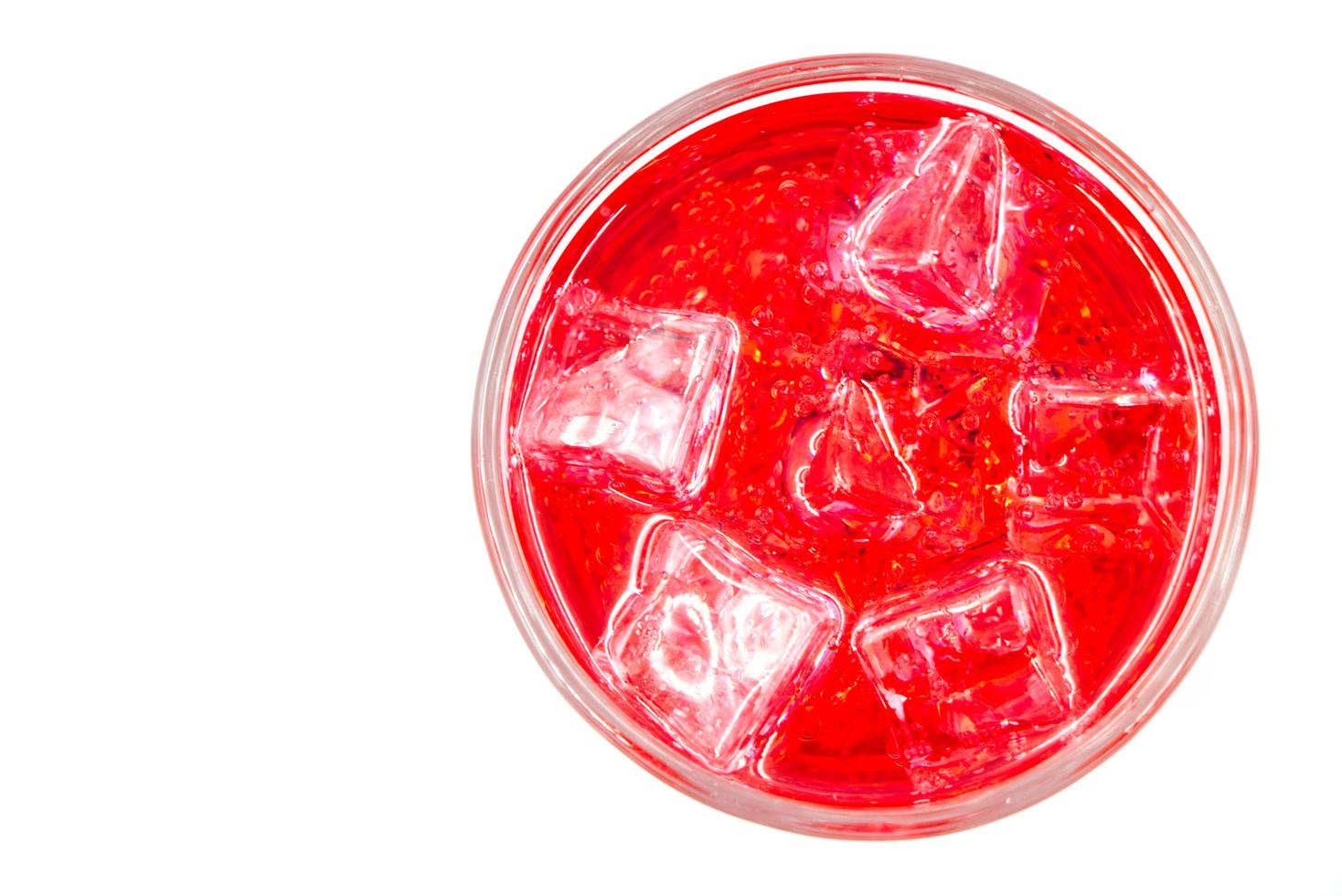 Red sparkling water with Ice in glass over white background. photo