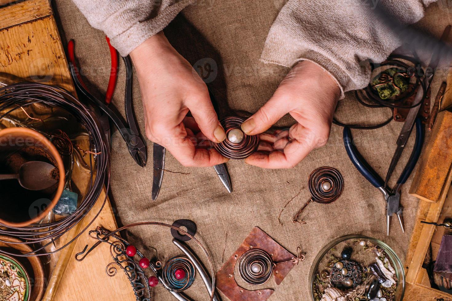 handmade copper wire working tools on the table with accessoires. handicraft people art concept photo