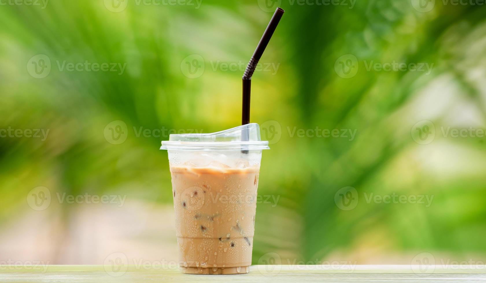 café helado en vaso alto, cubitos de hielo. bebida fresca de verano con pajitas sobre un cálido fondo verde natural. copie el espacio foto