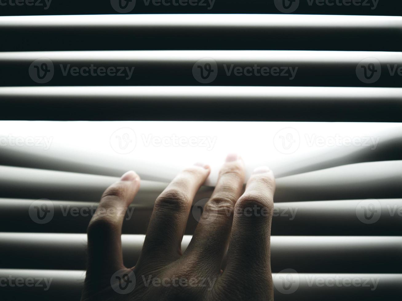 Hand is pushing closed blinds photo