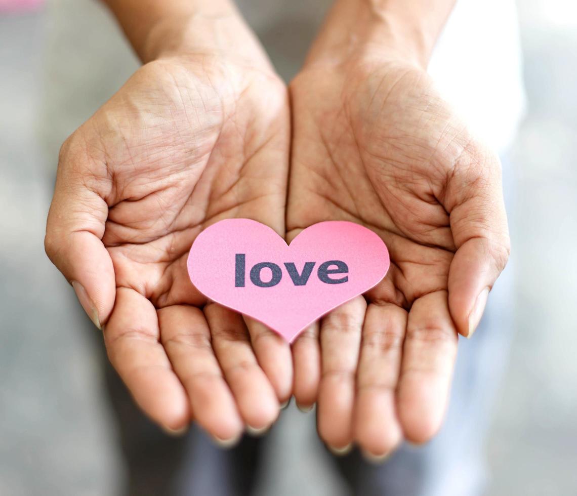 Hand holding heart pink card photo