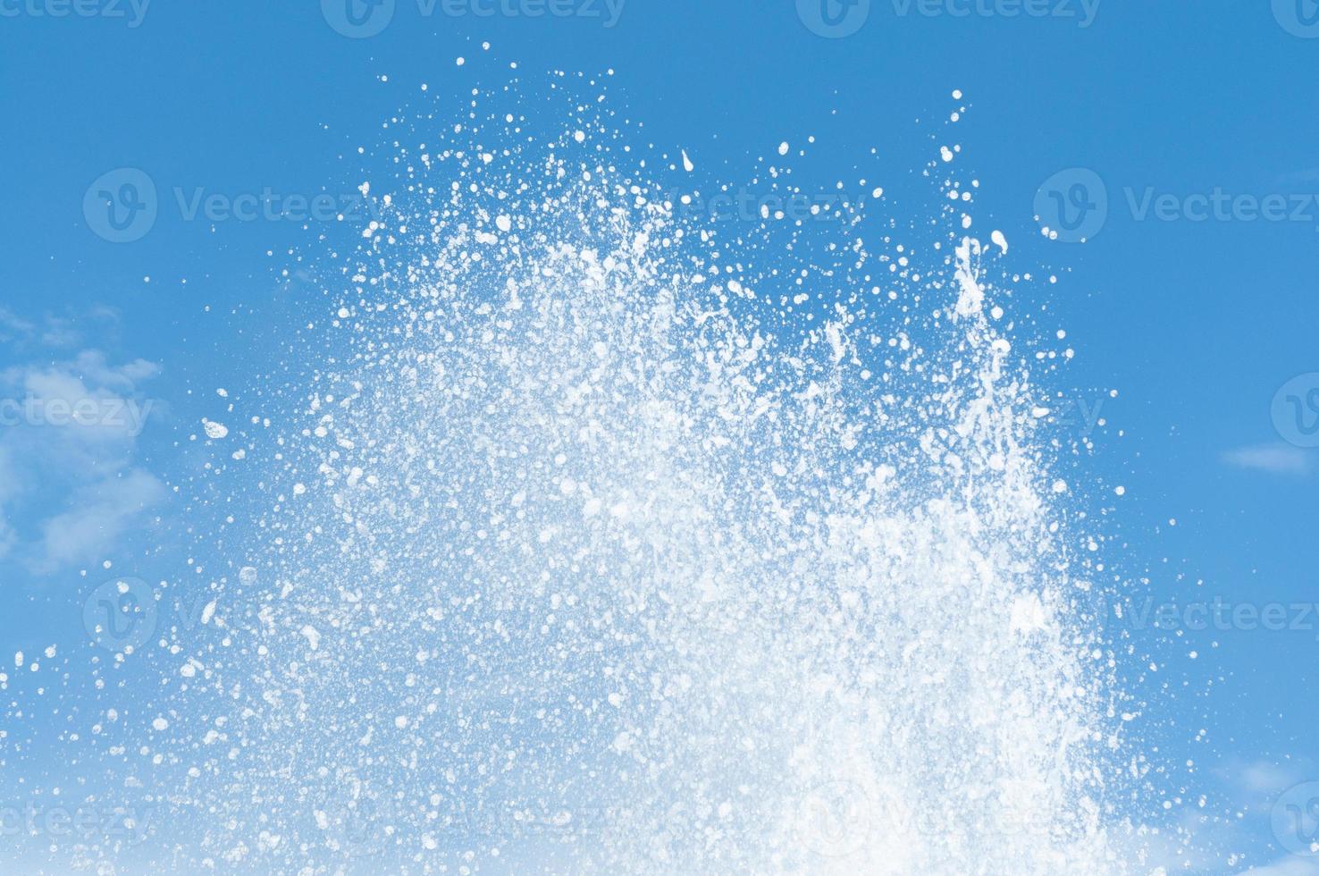 Cool and fresh water splashes on the clear blue sky background. photo