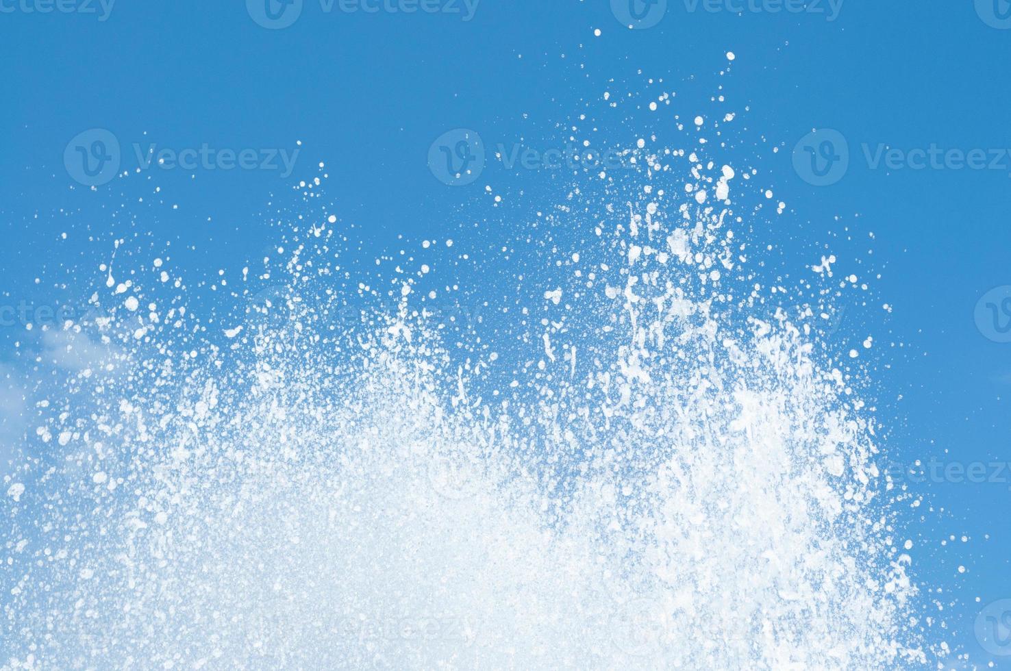 Cool and fresh water splashes on the clear blue sky background. photo