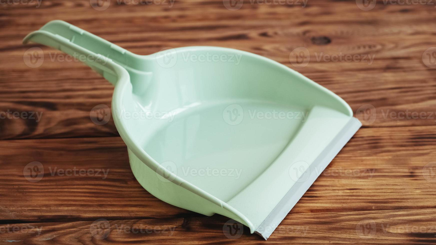 Plastic garbage scoop on a wooden background photo