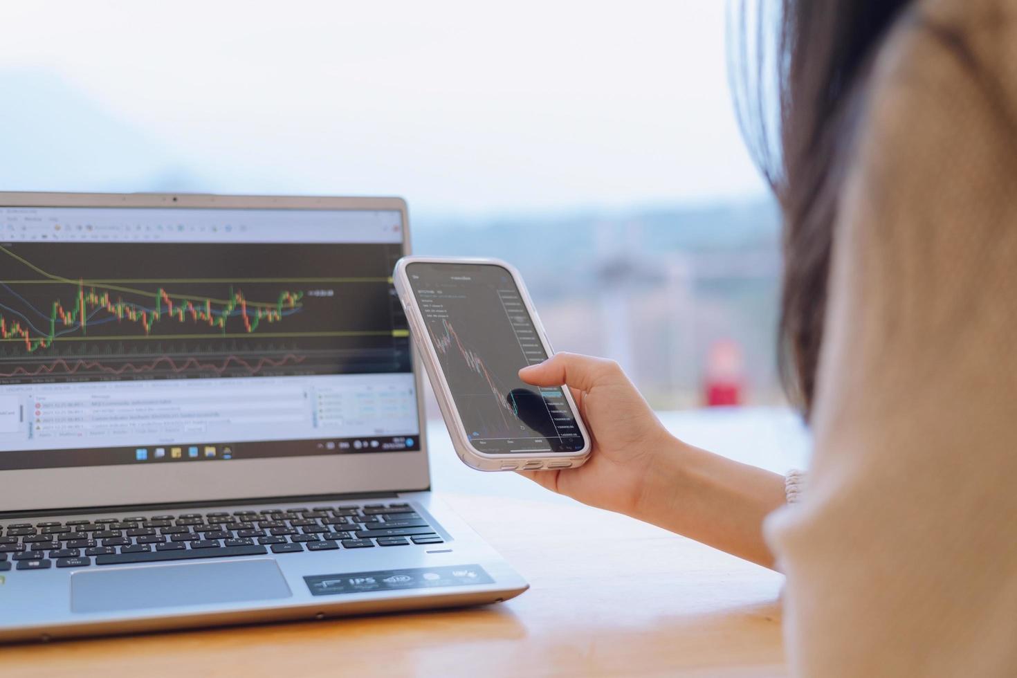 Woman is checking Bitcoin price chart on digital exchange on smartphone, cryptocurrency future price action prediction. photo