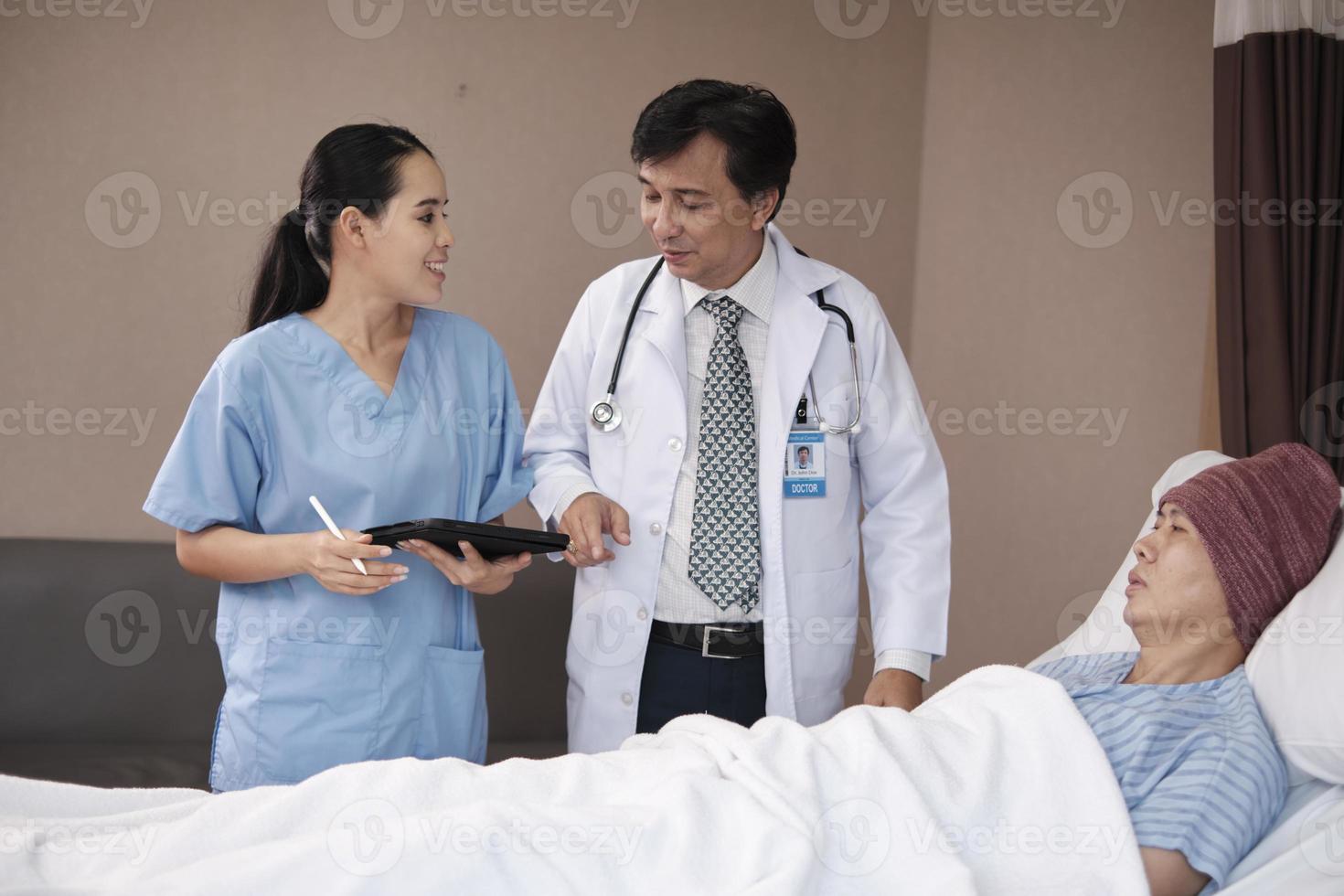 Professional doctors team in uniform health check Asian recovery male patient by stethoscope, medicine treatment at inpatient room bed in hospital ward, medical clinic, cancer examination consult. photo