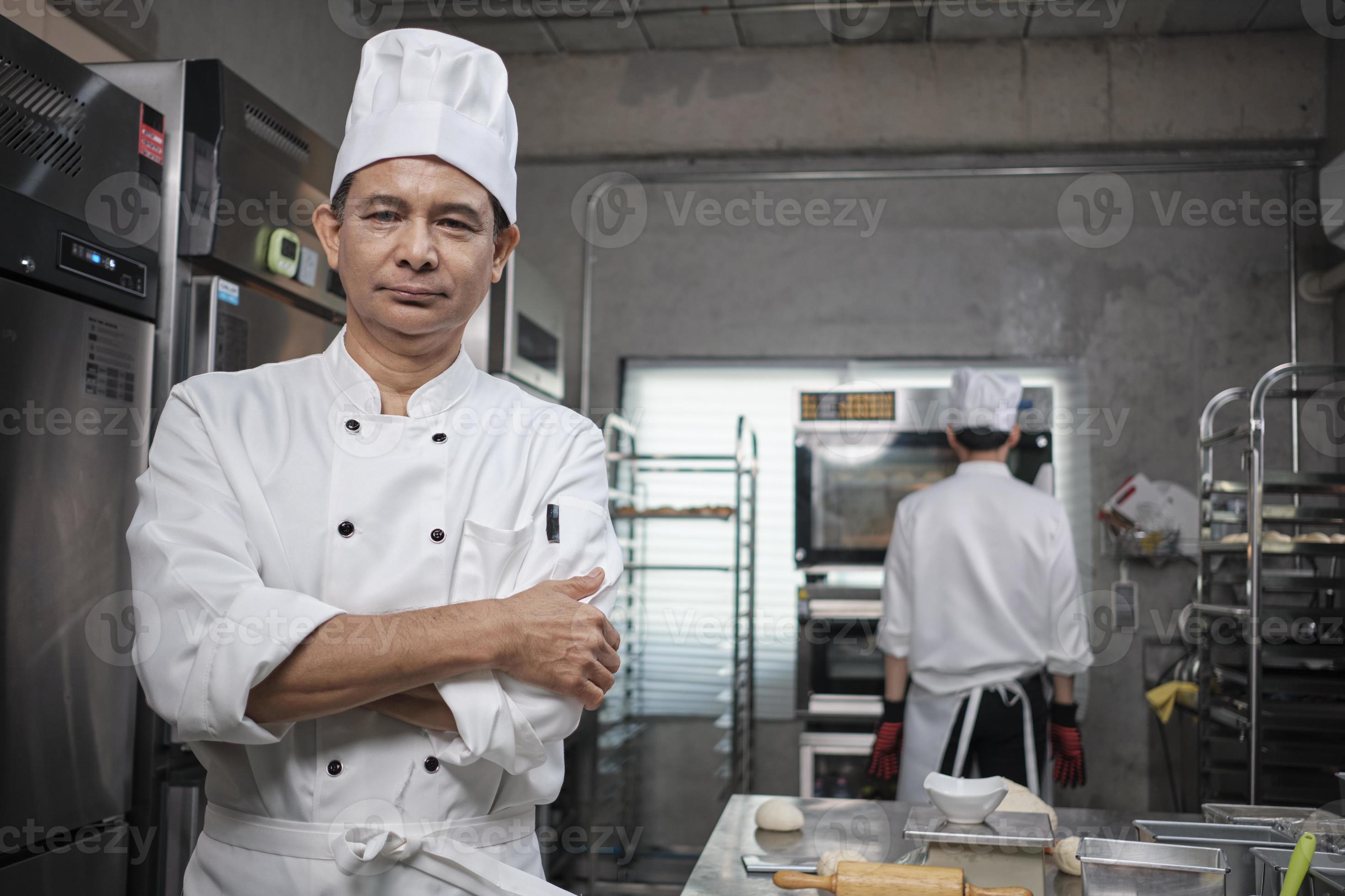 Professional Senior Asian Male Chef In White Cooking Uniform Food Occupation Looks At Camera 