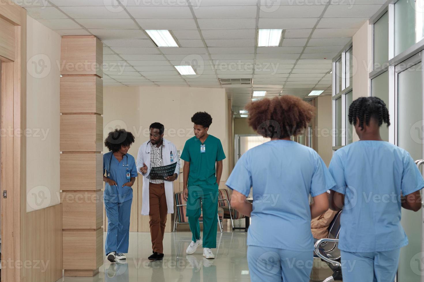 Interior atmosphere in working day times of the healthcare clinic, hospital's outpatient waiting area, groups of doctors and medical students talk and walk, discuss and consult patient examinations. photo