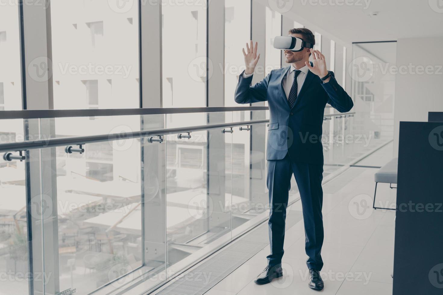 Successfu business professional in elegant suit standing in office and using VR technologies at work photo