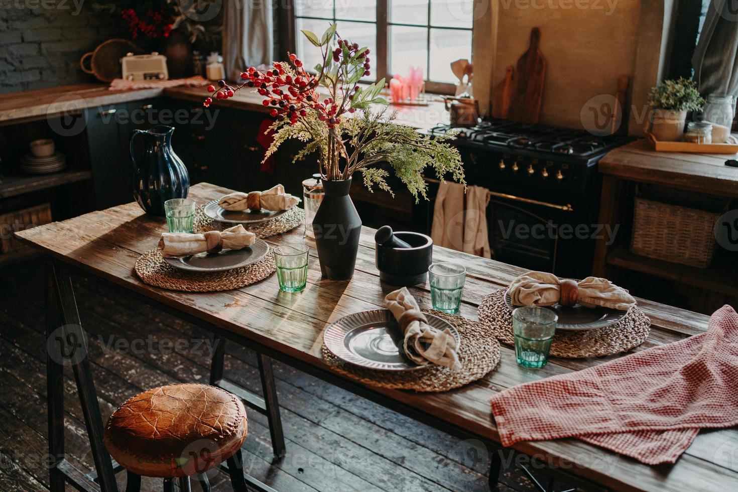 Table served for dinner. Cozy kitchen interior. Cultery and napkins on table for guests. Family breakfast. Dining time. No people. photo