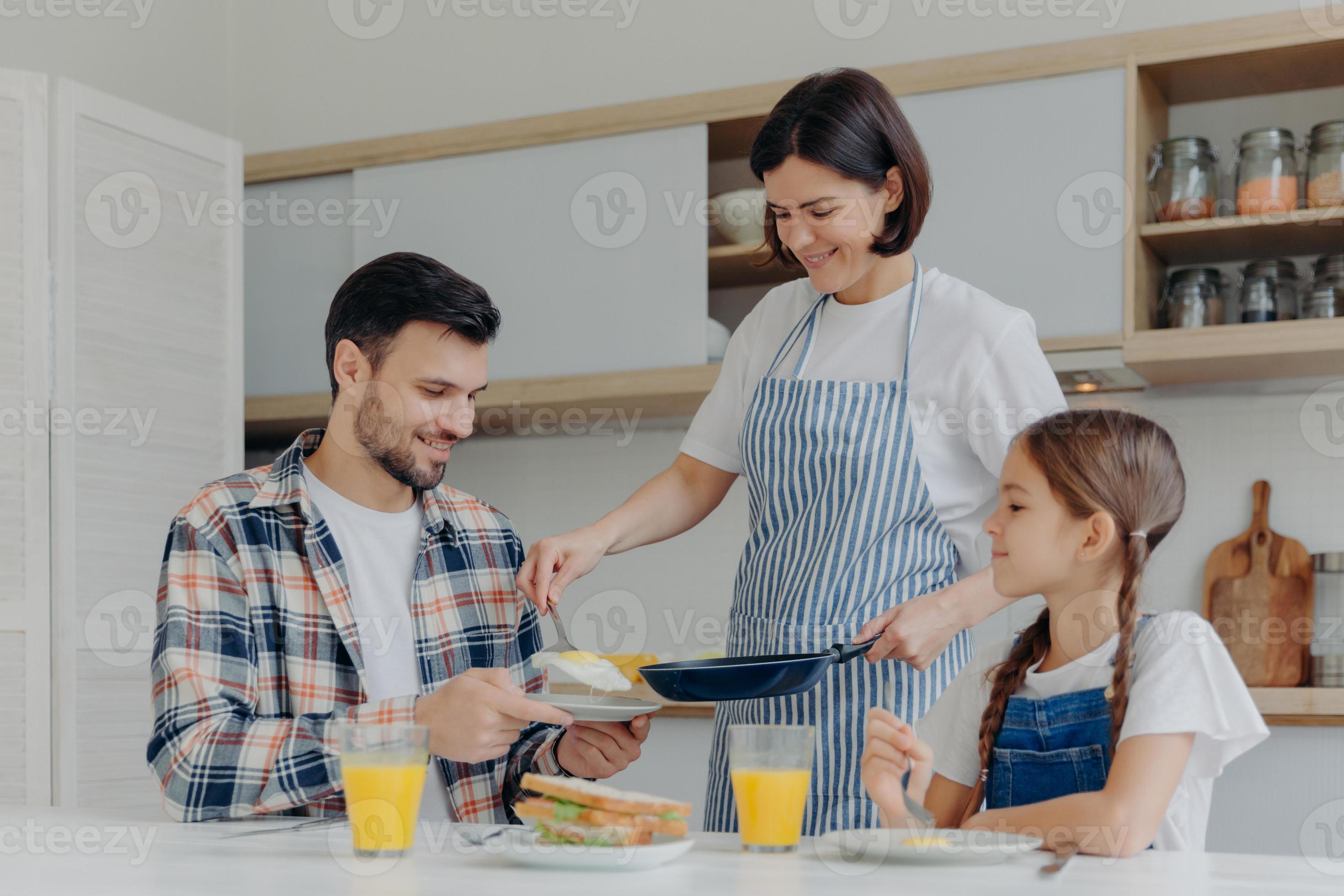 Busy housewife holds frying pan, gives