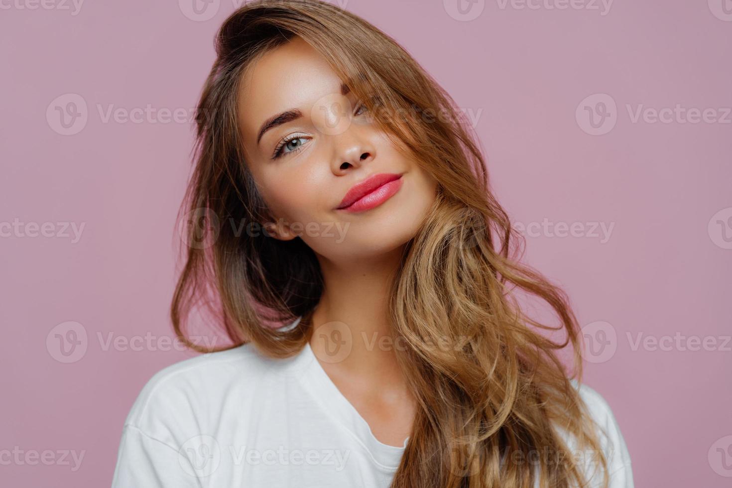 retrato de una joven modelo satisfecha y relajada inclina la cabeza, tiene  maquillaje, cabello rubio, vestido