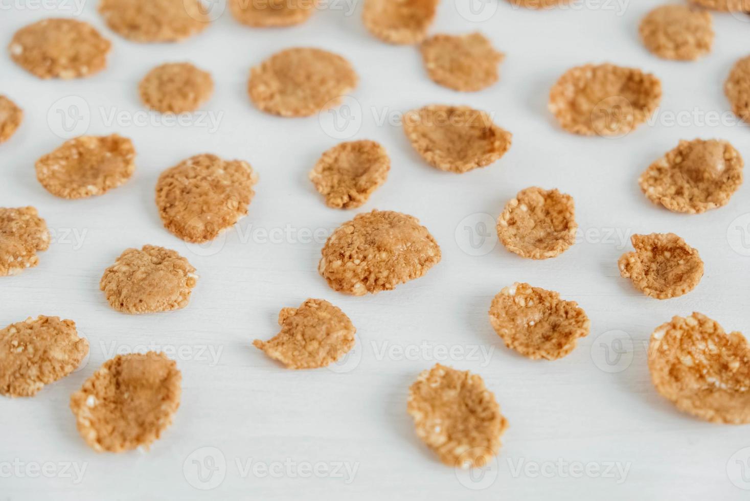 Crispy healthy dry cereal flakes on white background photo