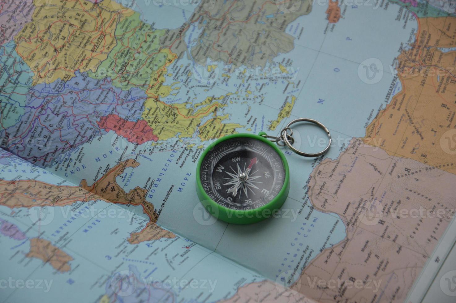 Hand compass for travel on the background of objects photo