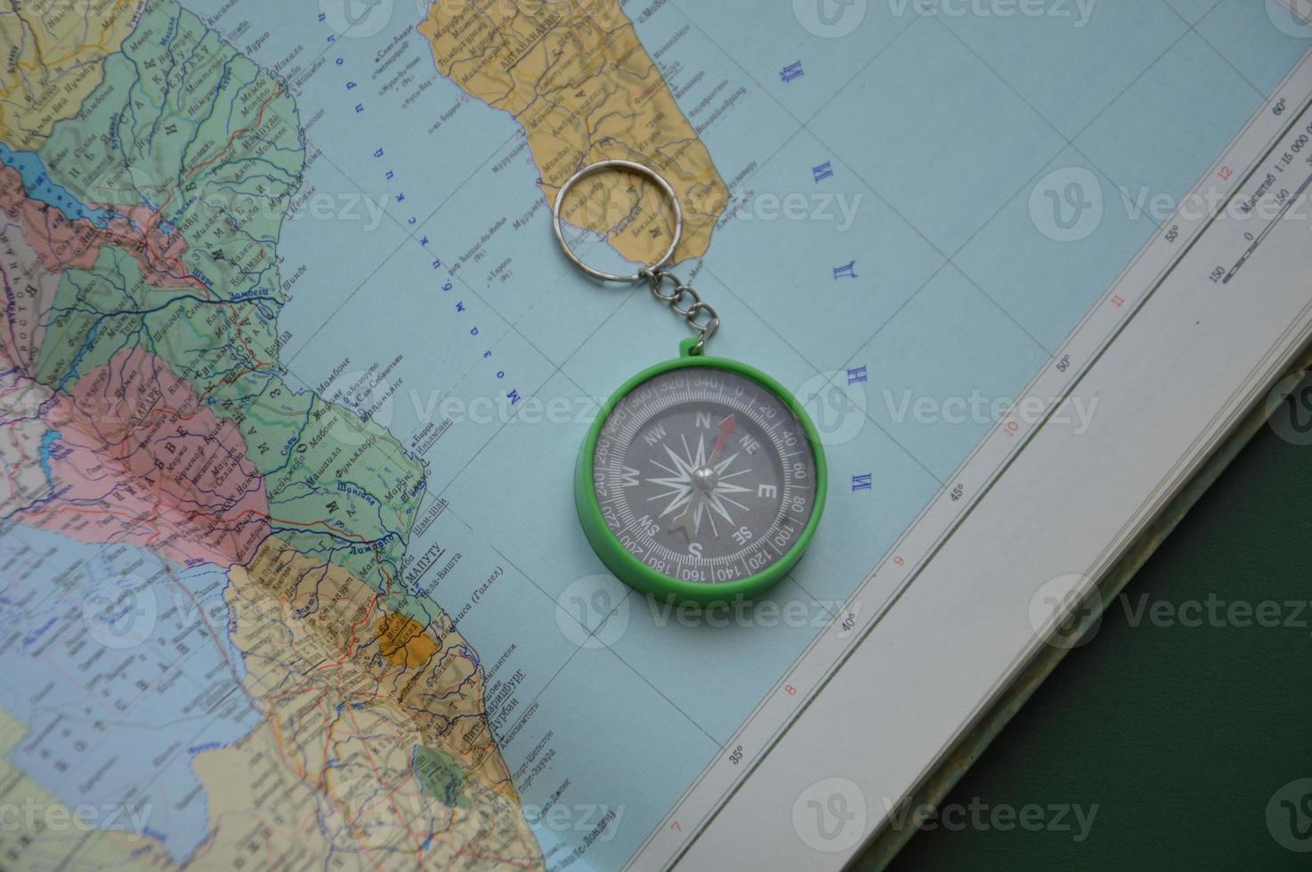 Hand compass for travel on the background of objects photo