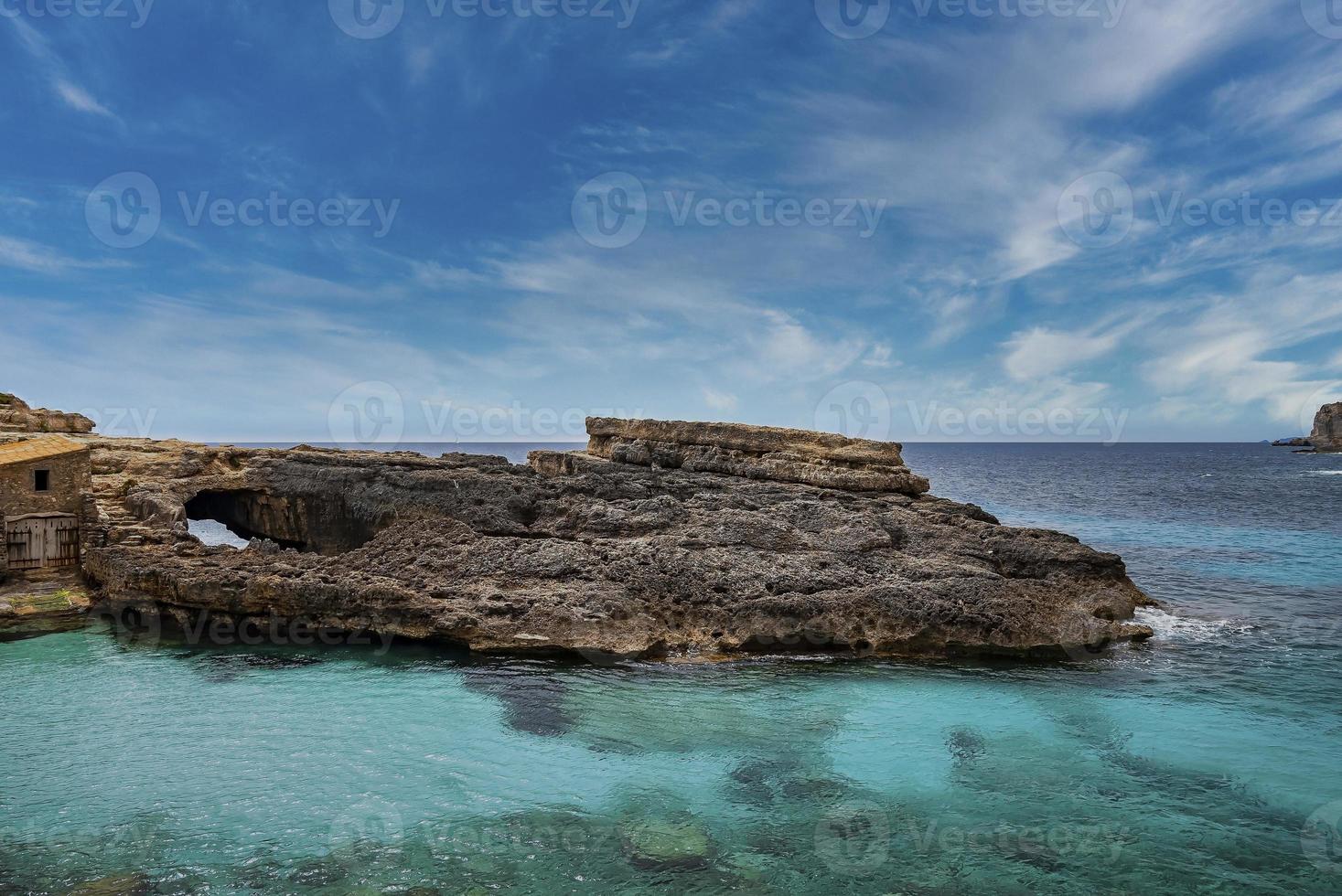 Idyllic view of rocky cliff on beautiful blue ocean in island against sky photo